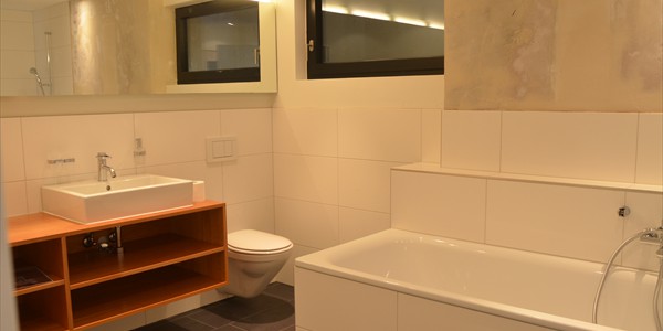 Das Badezimmer, der Rückzugspunkt für Hygiene und Wellness, mit verarbeitenden Feinsteinzeugplatten, die eine nur sehr minimale Wasseraufnahme aufweisen
